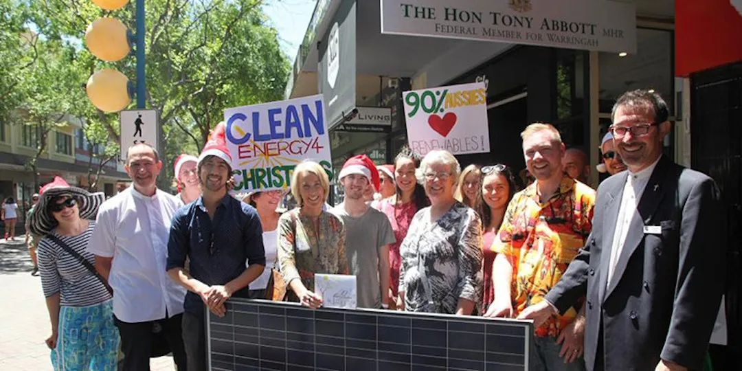 christians holding solar panel and positive solar signs in front of tony abbott's office