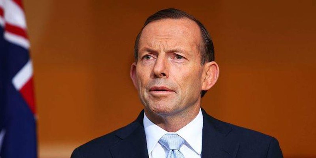 tony abbott in suit standing next to australian flag